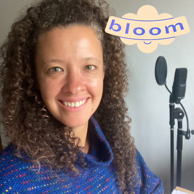 an image of choir leader fran andré smiling at the camera with a microphone in the background. Text reads 'Bloom'